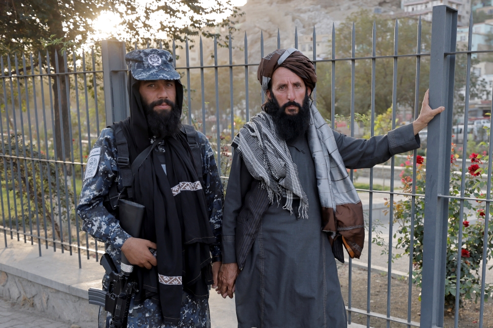 Members of Taliban forces, of which one is armed, pose at a check point after several civilians were killed in an explosion, in Kabul, Afghanistan October 3, 2021. Reuters/Jorge Silva