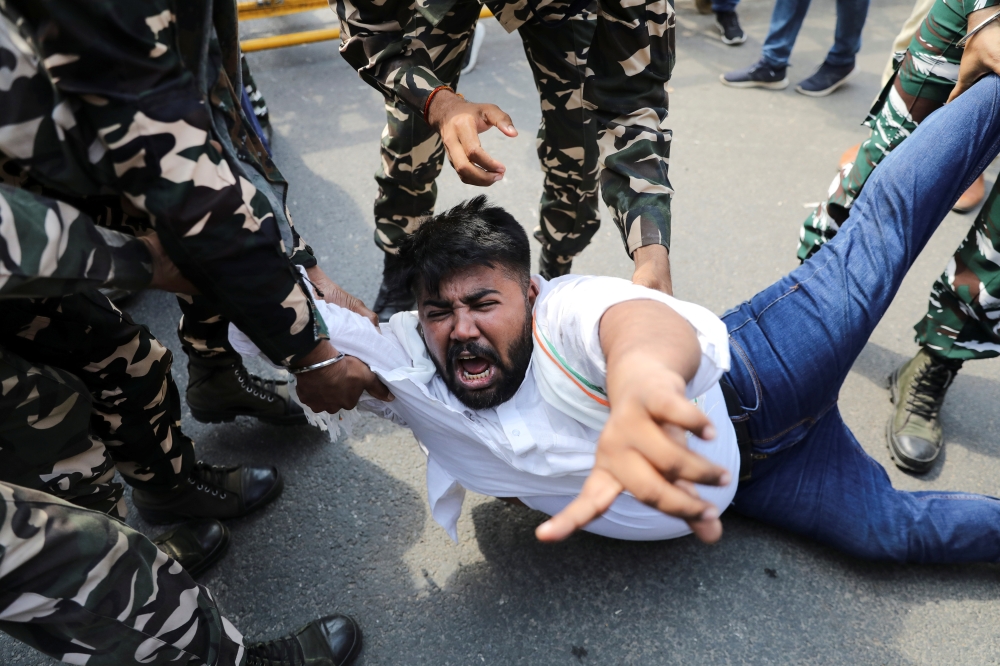 Police forces detain a man during a protest by activists of the youth wing of India's main opposition Congress party outside UP Bhawan, after people were killed when violence broke out in Uttar Pradesh state on Sunday, in New Delhi, India, October 4, 2021