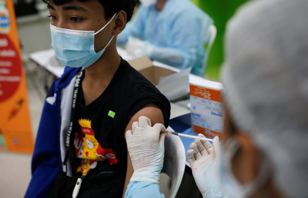 A high school student receives the Pfizer vaccine for the coronavirus disease (COVID-19) ahead of schools reopening in November, at a school in Bangkok, Thailand, October 4, 2021. REUTERS/Soe Zeya Tun
