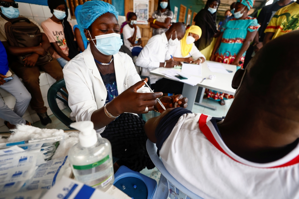 Aminata Laye Diagne, a nurse gives a dose of coronavirus disease (COVID-19) vaccine to a man at Philippe Senghor Hospital in Dakar, amid a surge of coronavirus disease (COVID-19) cases in Senegal July 28, 2021. REUTERS/Zohra Bensemra/File Photo