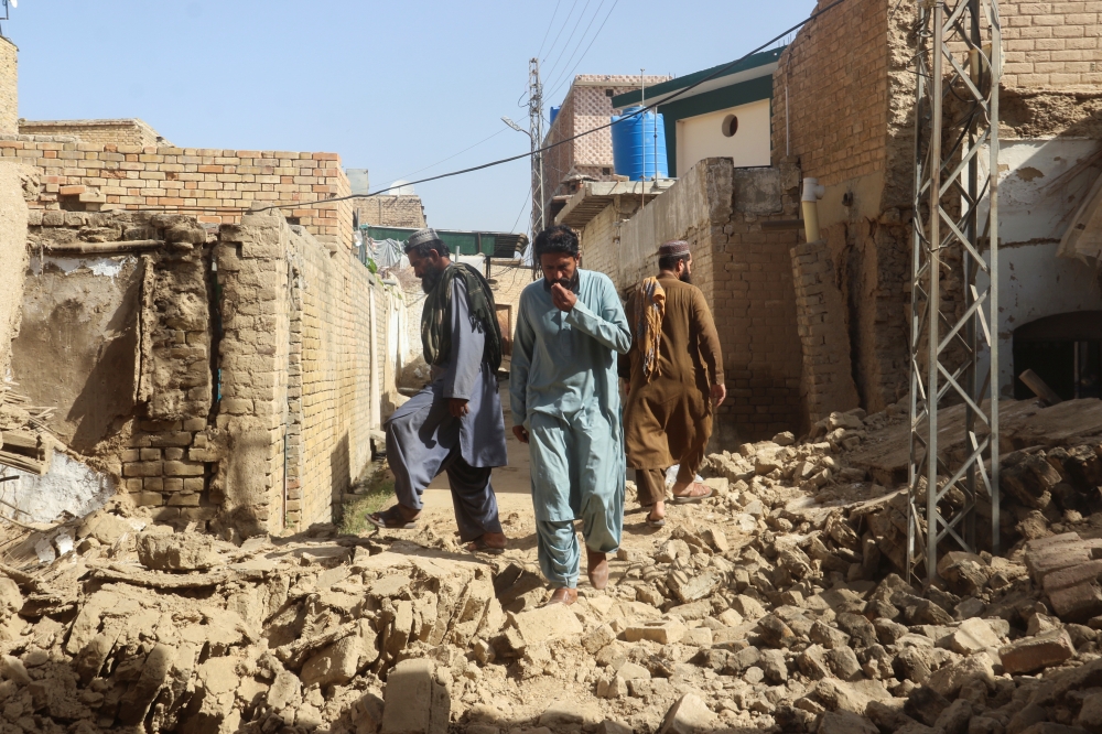 Residents walk amid the rubble of damaged houses along a street following an earthquake in Harnai, Balochistan, Pakistan, October 7, 2021. Reuters/Naseer Ahmed