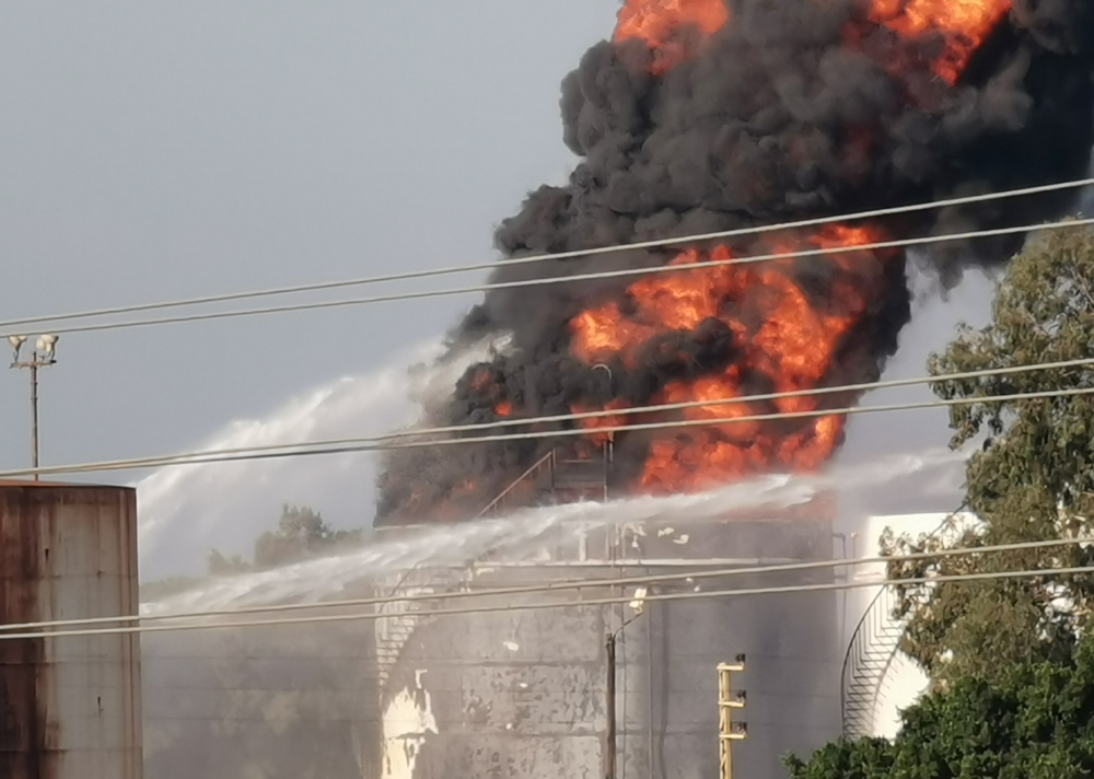 Water is sprayed at a fire in the Zahrani oil facility in southern Lebanon, October 11, 2021. Reuters/Ali Hankir 
