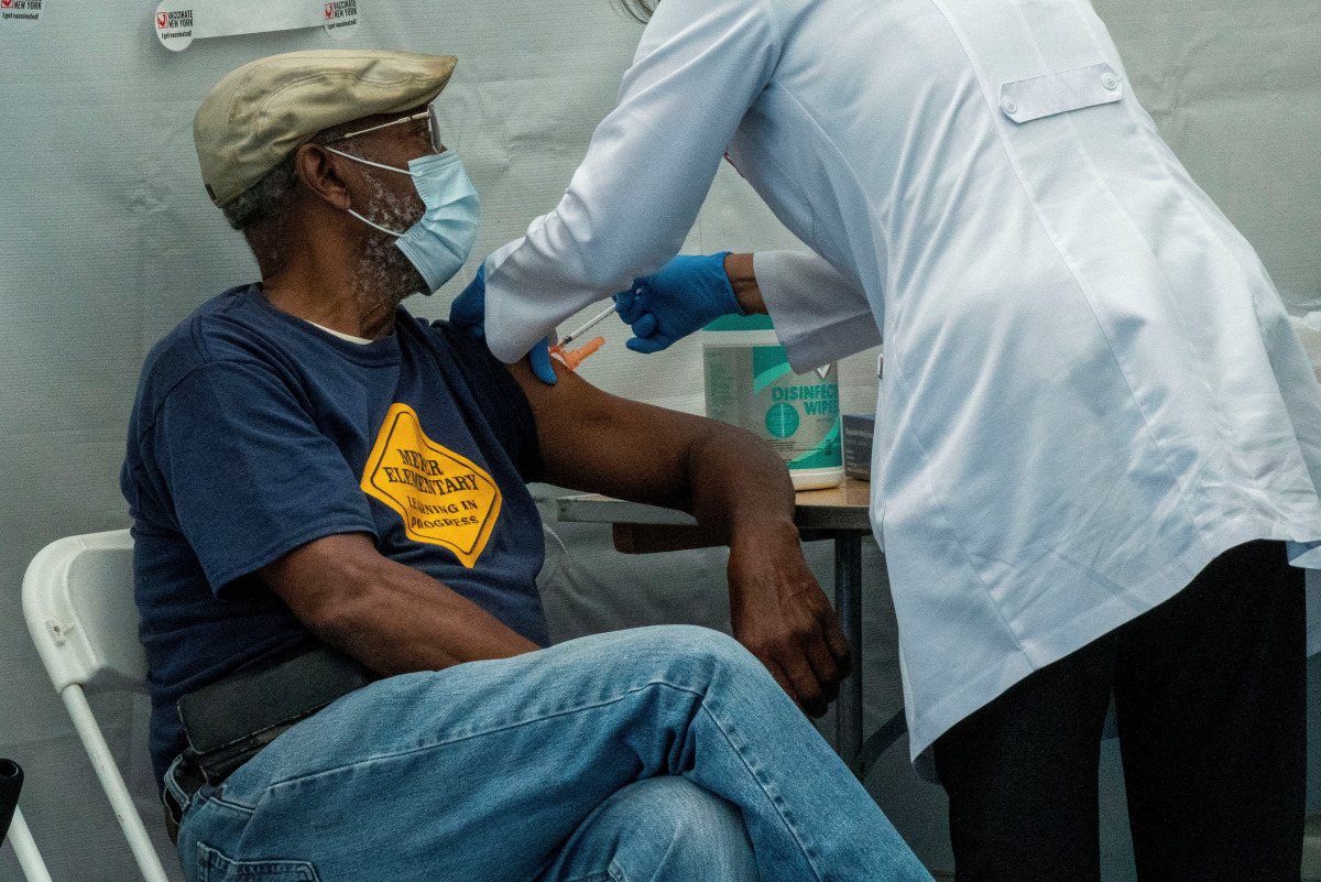 FILE PHOTO: A person receives a dose of the Pfizer-BioNTech vaccine for the coronavirus disease (COVID-19) as New York State Governor Kathy Hochul speaks during a news conference about the coronavirus disease (COVID-19) vaccination mandate for healthcare 