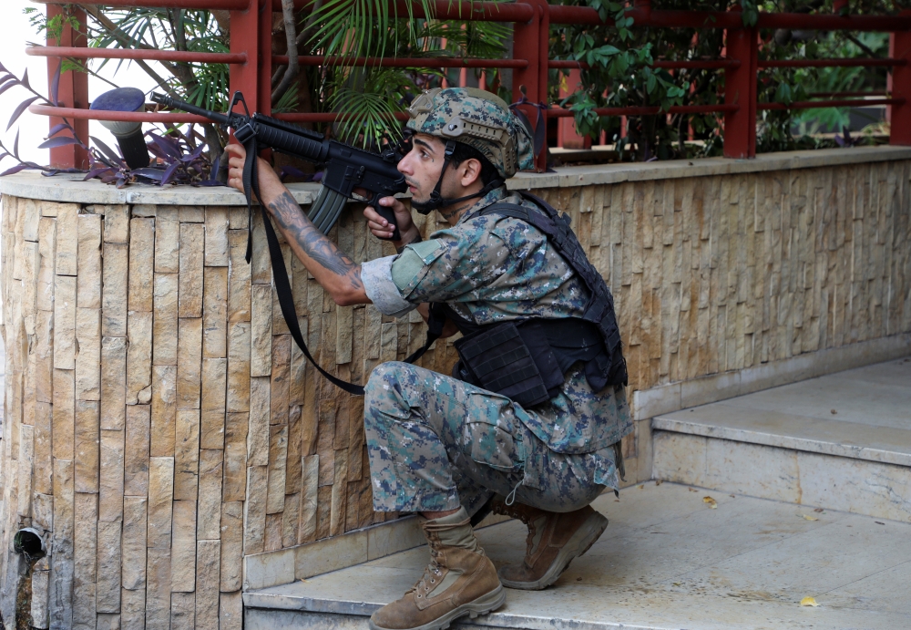 An army soldier takes position after gunfire erupted at a site near a protest that was getting underway against Judge Tarek Bitar, who is investigating last year's port explosion, in Beirut, Lebanon October 14, 2021. Reuters/Mohamed Azakir