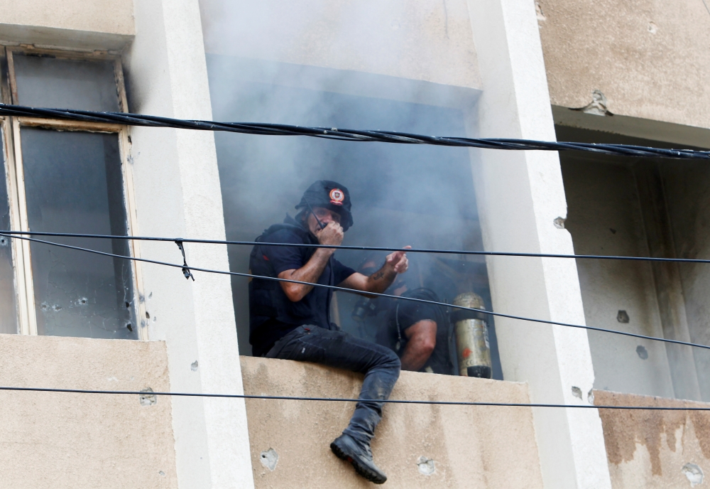 Civil defence members attempt to put out a fire inside a building after gunfire erupted in Beirut, Lebanon October 14, 2021. (REUTERS/Aziz Taher)