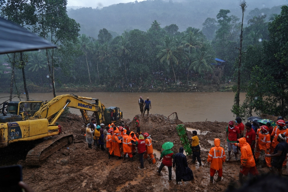 Rescue workers carry the body of a victim after recovering it from the debris of a residential house following a landslide caused by heavy rainfall at Kokkayar village in Idukki district in the southern state of Kerala, India, October 17, 2021. REUTERS/St