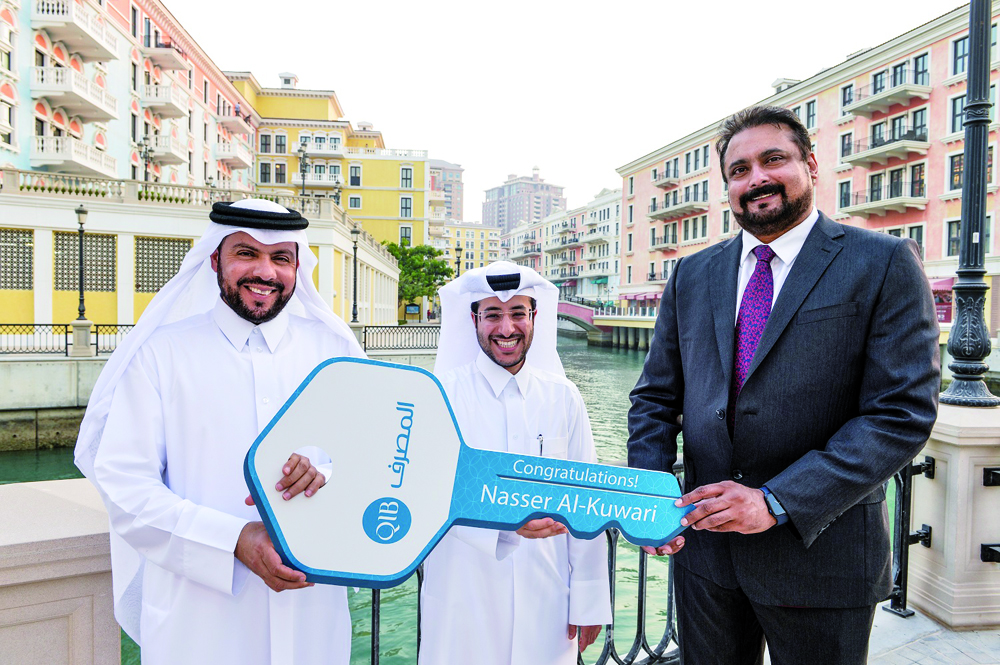 QIB’s grand prize winner Nasser Al Kuwari receives the key for his new apartment at The Pearl-Qatar.  