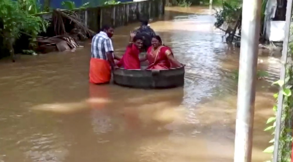 Bride and groom float to a temple in a cooking vessel on a flooded road for their wedding ceremony in this screengrab taken from video, in Alappuzha, Kerala, India, October 18, 2021. REUTERS TV/via REUTERS