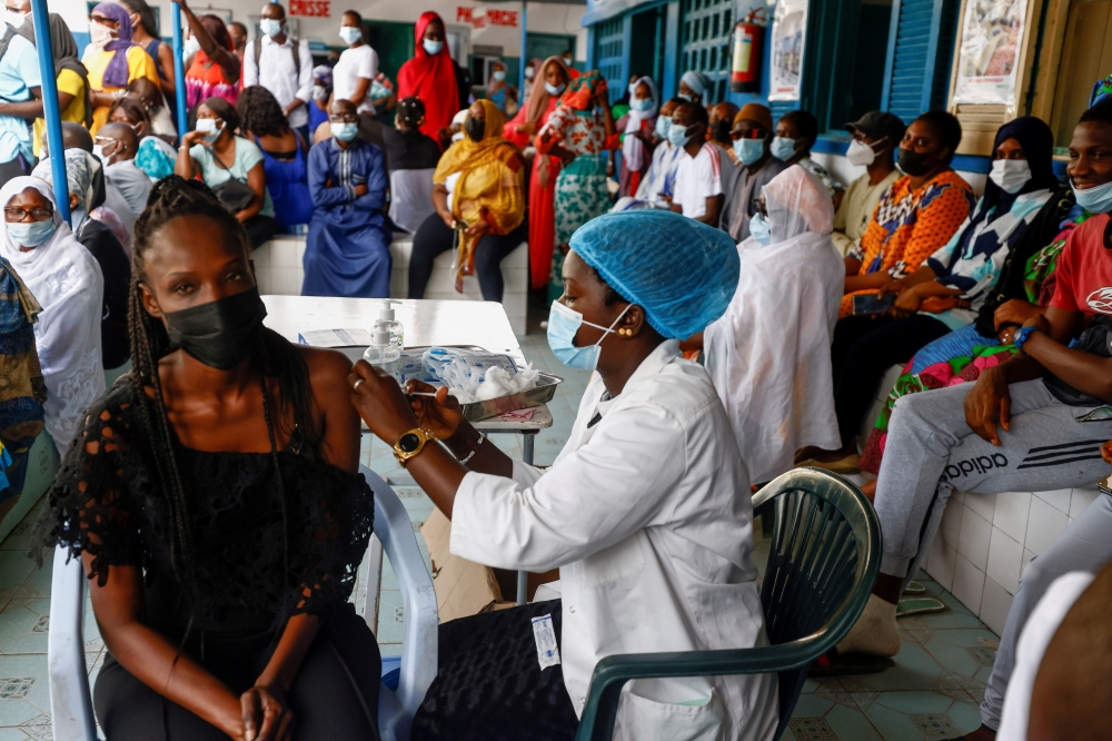 Aminata Laye Diagne, a nurse gives a dose of coronavirus disease (COVID-19) vaccine to a woman at Philippe Senghor Hospital in Dakar, amid a surge of coronavirus disease (COVID-19) cases in Senegal July 28, 2021. .REUTERS/Zohra Bensemra/File Photo/File Ph