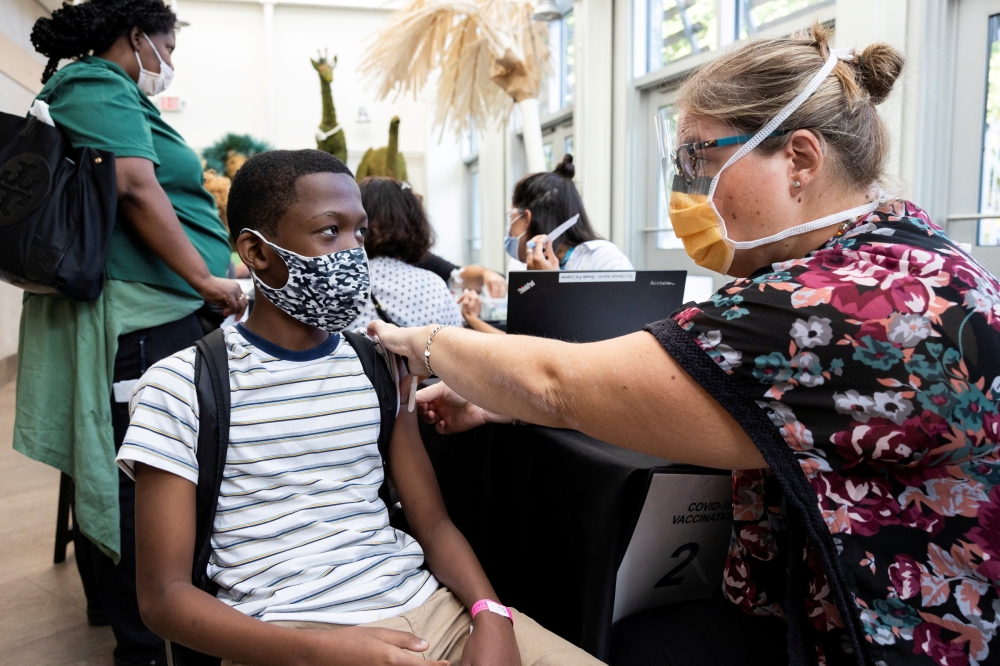 FILE PHOTO: A child gets his second dose of the coronavirus disease (COVID-19) vaccine at the Philadelphia Zoo in Philadelphia, Pennsylvania, U.S., September 7, 2021. REUTERS/Rachel Wisniewski