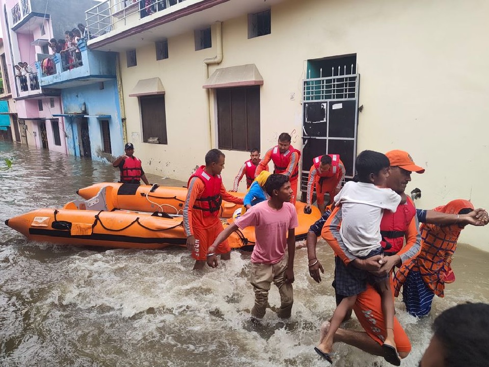 Members of National Disaster Response Force (NDRF) evacuate people to safer places from a flooded area in Udham Singh Nagar in the northern state of Uttarakhand, India, October 19, 2021. National Disaster Response Force/Handout via REUTERS