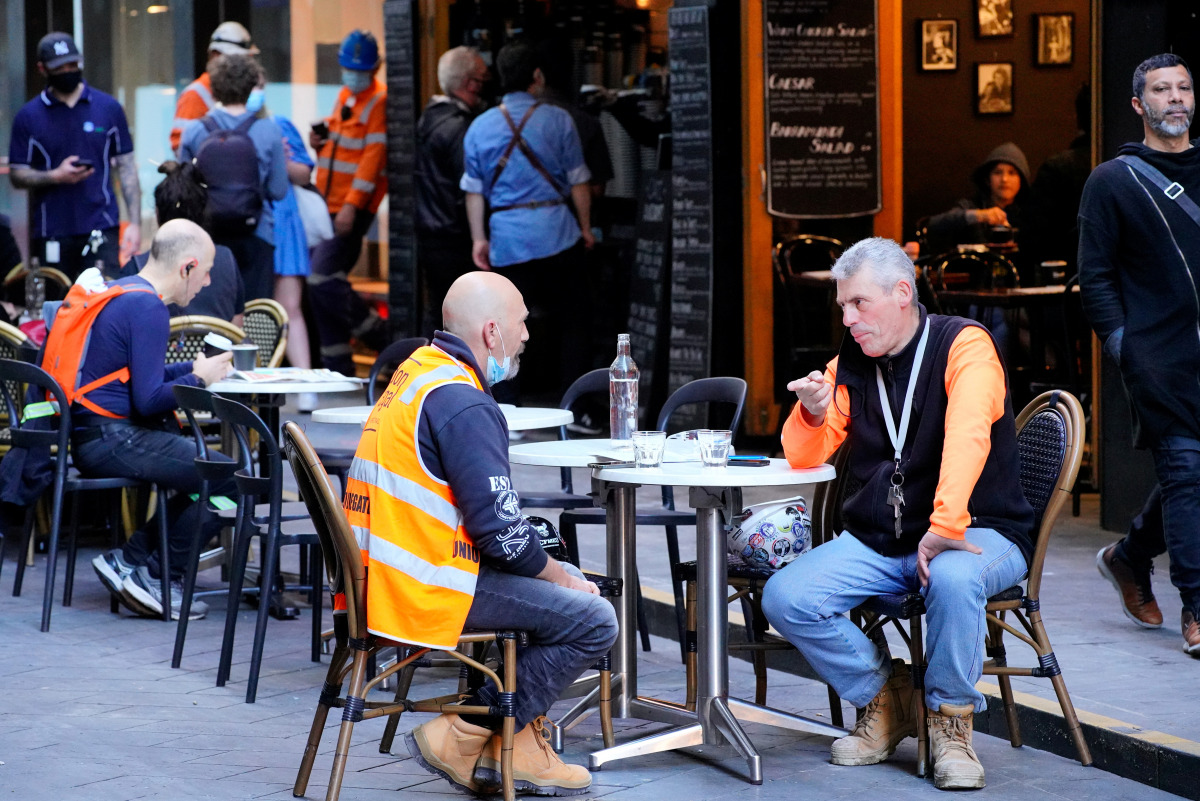 Diners eat outside at a cafe on the first day of eased coronavirus disease (COVID-19) regulations, following a lockdown to curb an outbreak, in Melbourne, Australia, October 22, 2021. REUTERS/Sandra Sanders
