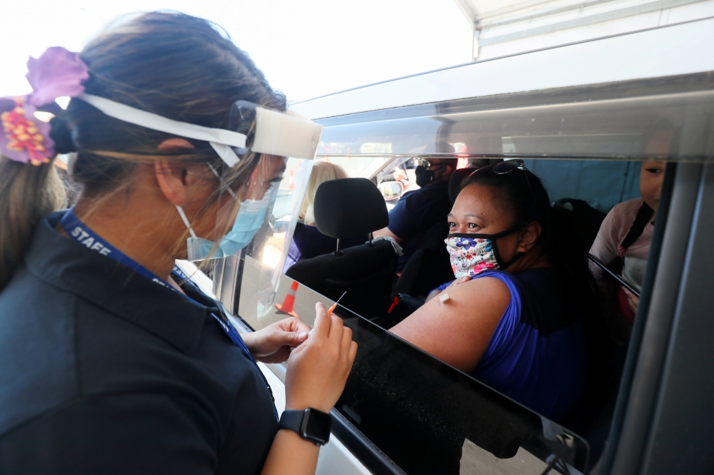 A member of the public receives a Pfizer vaccine at a drive-through coronavirus disease (COVID-19) vaccination clinic in Otara during a single-day vaccination drive, aimed at significantly increasing the percentage of vaccinated people in the country, in 