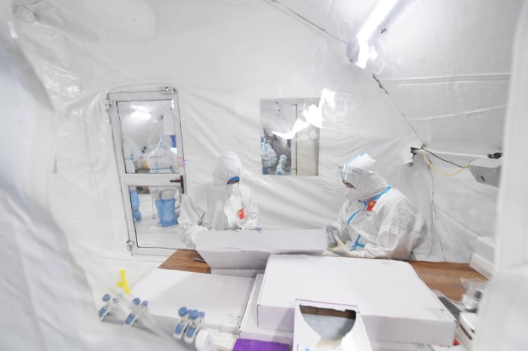 Workers in protective suits work inside a makeshift nucleic acid testing laboratory during a mass testing following local cases of the coronavirus disease (COVID-19) in Lanzhou, Gansu province, China October 25, 2021. Picture taken October 25, 2021. cnsph