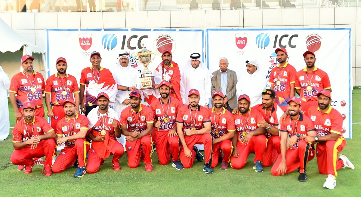 Bahrain players and officials celebrate with the champions' trophy after securing a place in one of the global qualifiers, yesterday. Pictures: Abdul Basit / The Peninsula 
