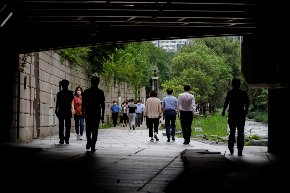 People wearing masks take a walk amid the coronavirus disease (COVID-19) pandemic in Seoul, South Korea, July 7, 2021. REUTERS/ Heo Ran
