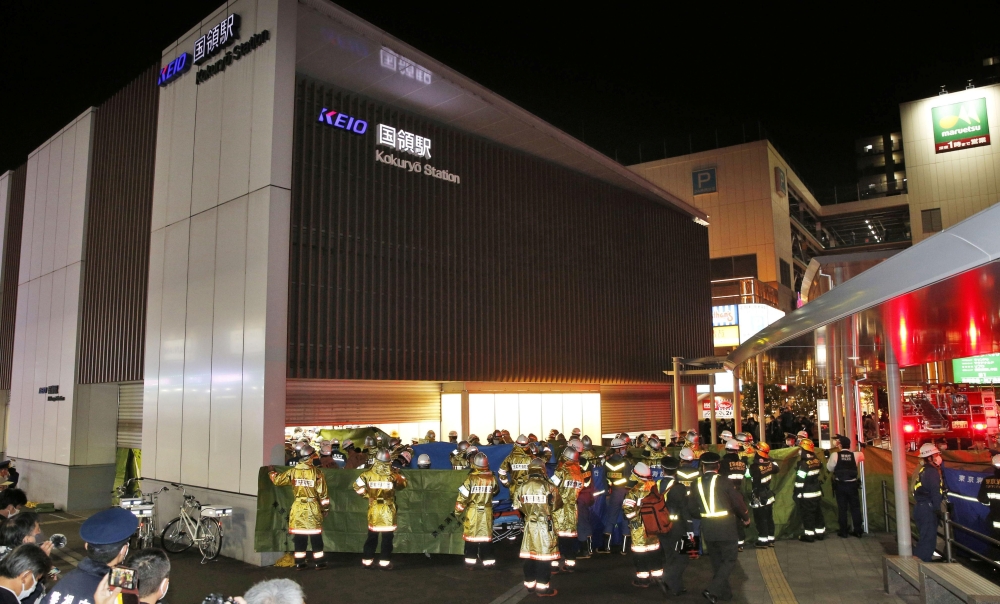 Rescue workers and police officers work at the site where a knife, arson and acid attack incident occurred on a train, at the Kokuryo station of the Keio Line train in Tokyo, Japan October 31, 2021 in this photo taken by Kyodo. Mandatory credit Kyodo/via REUTERS
