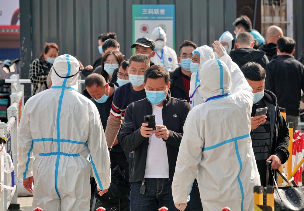 Workers in protective suits inspect the health information of passengers leaving Yantai Railway Station following the recent outbreak of the coronavirus disease (COVID-19), in Yantai, Shandong province, China November 2, 2021. China Daily via REUTERS