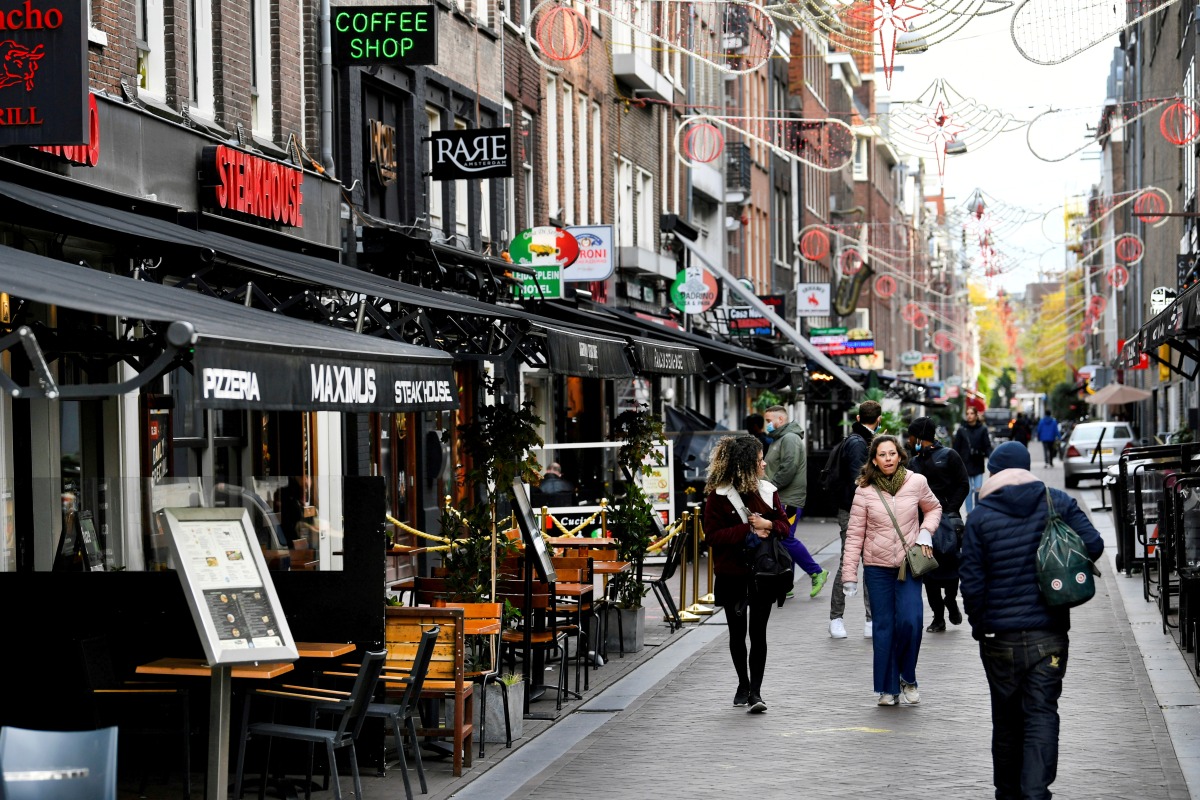 FILE PHOTO: People walk past restaurants and cafes in Amsterdam, Netherlands October 14 2020. REUTERS/Piroschka van de Wouw/File Photo
