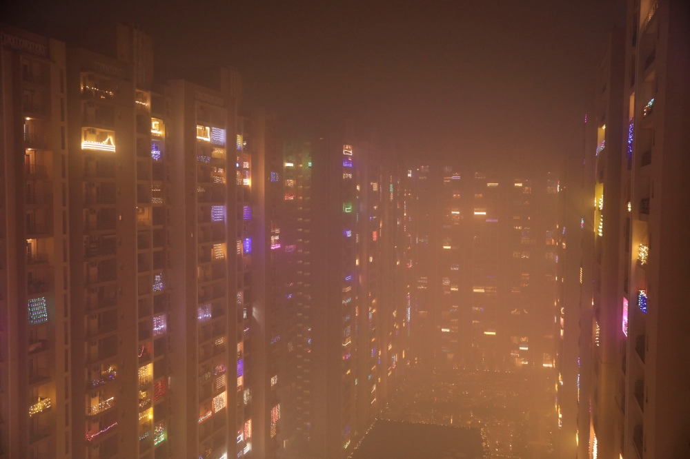 Lights decorating the balconies of a high-rise are seen shrouded in smog in Noida, India, November 5, 2021. Reuters/Anushree Fadnavis