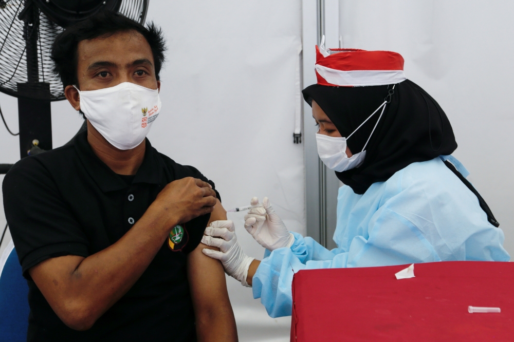 A man receives a dose of a vaccine against the coronavirus disease (COVID-19) during a vaccination program in Jakarta, Indonesia, August 16, 2021. REUTERS/Ajeng Dinar Ulfiana/File Photo