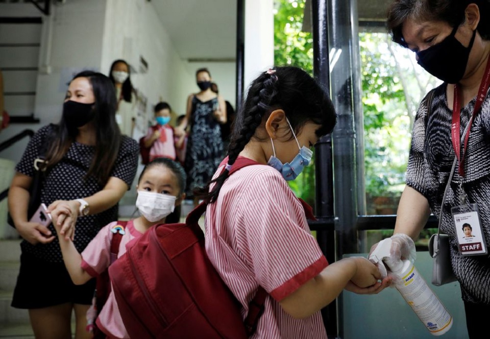 Children wearing protective face masks sanitise their hands as they attend preschool classes at St James' Church Kindergarten as schools reopen amid the coronavirus disease (COVID-19) outbreak in Singapore June 2, 2020. REUTERS/Edgar Su