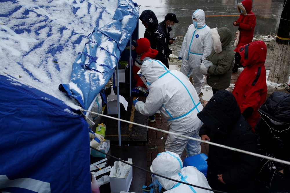 People line up for nucleic acid testing in the snow at a testing site in Jinpu New Area, following cases of the coronavirus disease (COVID-19) in Dalian, Liaoning province, China November 8, 2021. Picture taken November 8, 2021. cnsphoto via REUTERS