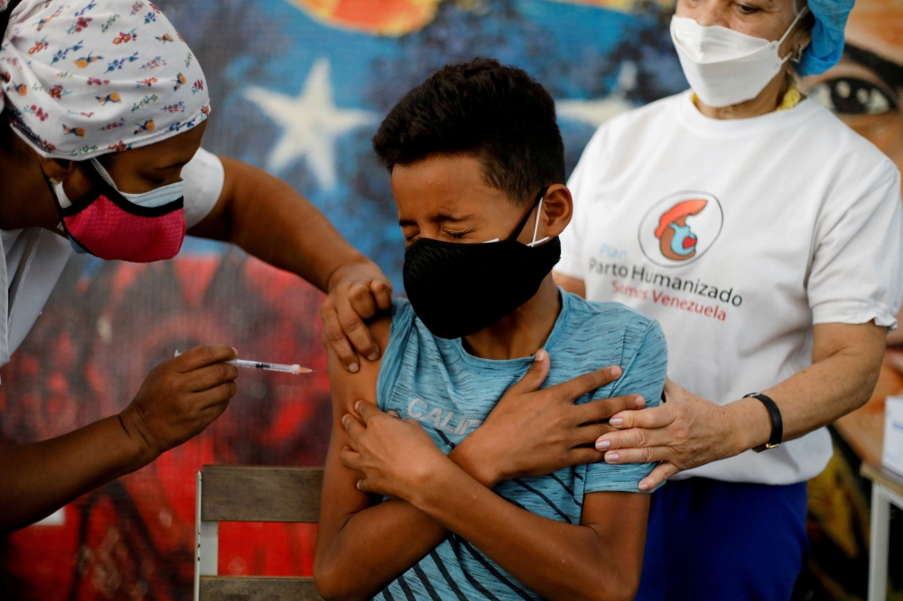 A public school student receives a dose of the Sinopharm vaccine against the coronavirus disease (COVID-19) as part of a vaccination campaign for adolescents, in Caracas, Venezuela October 27, 2021. REUTERS/Leonardo Fernandez Viloria/File Photo
