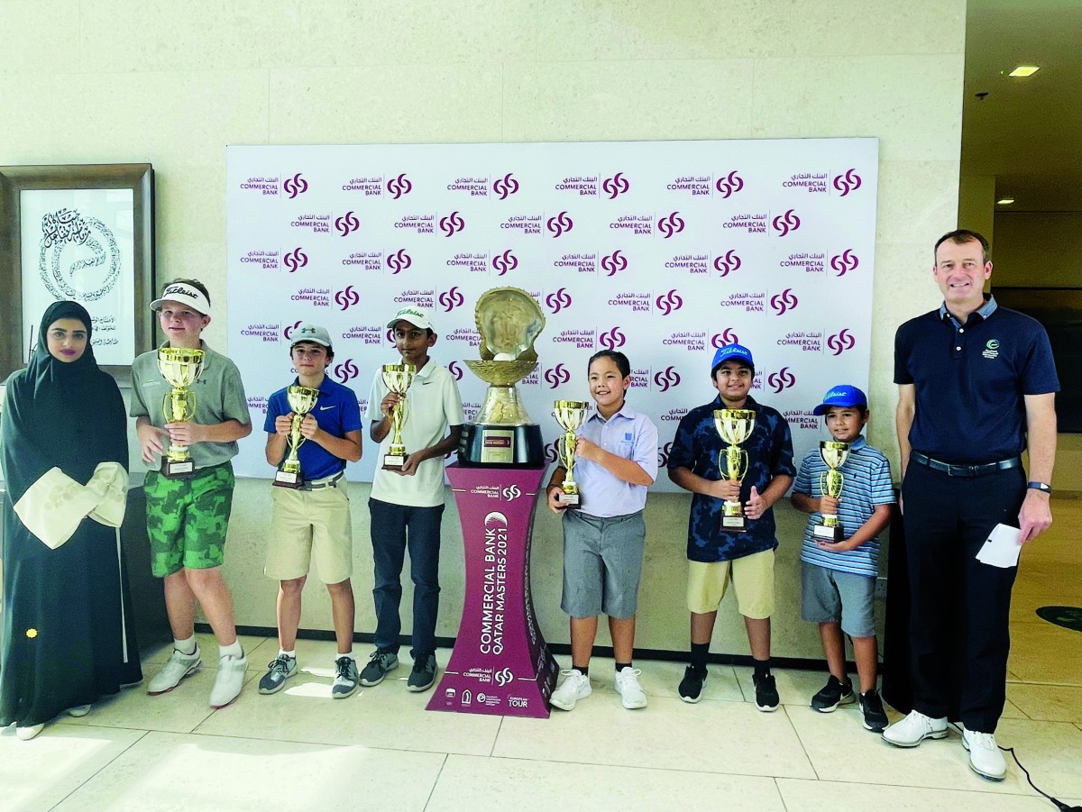 Young golfers pose with their trophies.
