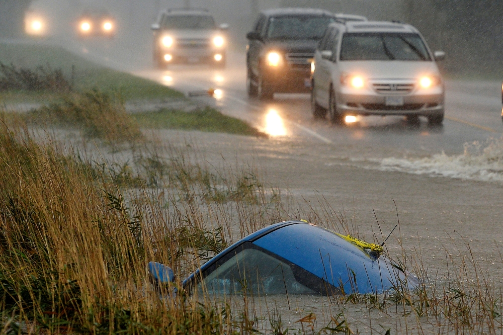 A car lies submerged in a ditch on a flooded stretch of road after rainstorms lashed the western Canadian province of British Columbia, triggering landslides and floods, shutting highways, in Chilliwack, British Columbia, Canada November 15, 2021. REUTERS/Jennifer Gauthier