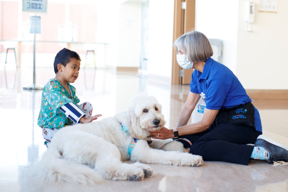 Kristin Gist and her dog Ollie greet patient Ricardo Martin, 6, with the return of the canine program at Rady Children's Hospital in San Diego, California, US, November, 11, 2021. Reuters/Mike Blake