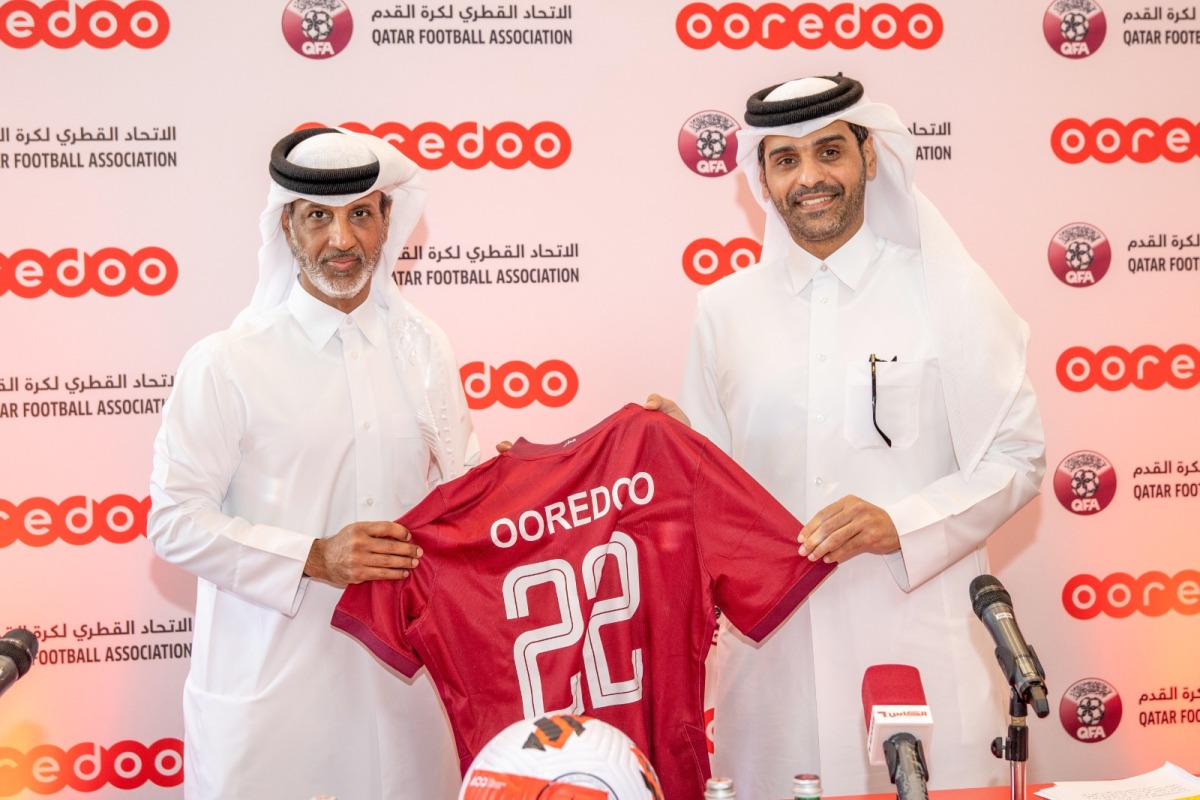 Qatar Football Association President Sheikh Hamad bin Khalifa bin Ahmed Al Thani presents a Qatar team jersey to CEO of Ooredoo Sheikh Mohammed bin Abdulla Al Thani after the sponsorship signing ceremony.