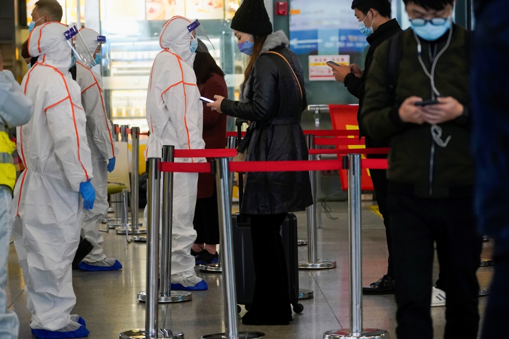 Security guards block an exit as they directs people to scan a QR code to track their health status at Shanghai Hongqiao Railway Station, following new cases of the coronavirus disease (COVID-19), in Shanghai, China, November 25, 2021. Picture taken November 25, 2021. REUTERS/Aly Song
 