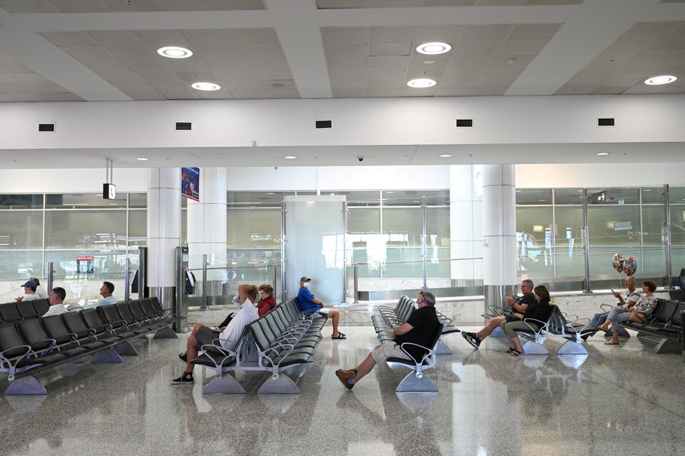 People sit in the arrivals section of the international terminal of Kingsford Smith International Airport. Reuters/Loren Elliott
