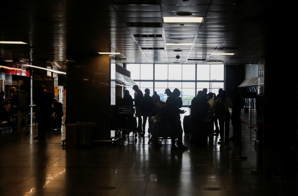 Passengers queue at the Kenya Airways ticket sales counter to book flights as several airlines have stopped flying out of South Africa, amidst the spread of the new SARS-CoV-2 variant Omicron, at O.R. Tambo International Airport in Johannesburg, South Africa, November 28, 2021. REUTERS/ Sumaya Hisham