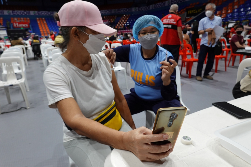 Wendilyn Cabornay, 65, takes a selfie while being inoculated at a vaccination centre in San Juan City, Metro Manila, in the Philippines, November 29, 2021. Reuters/ Peter Blaza
