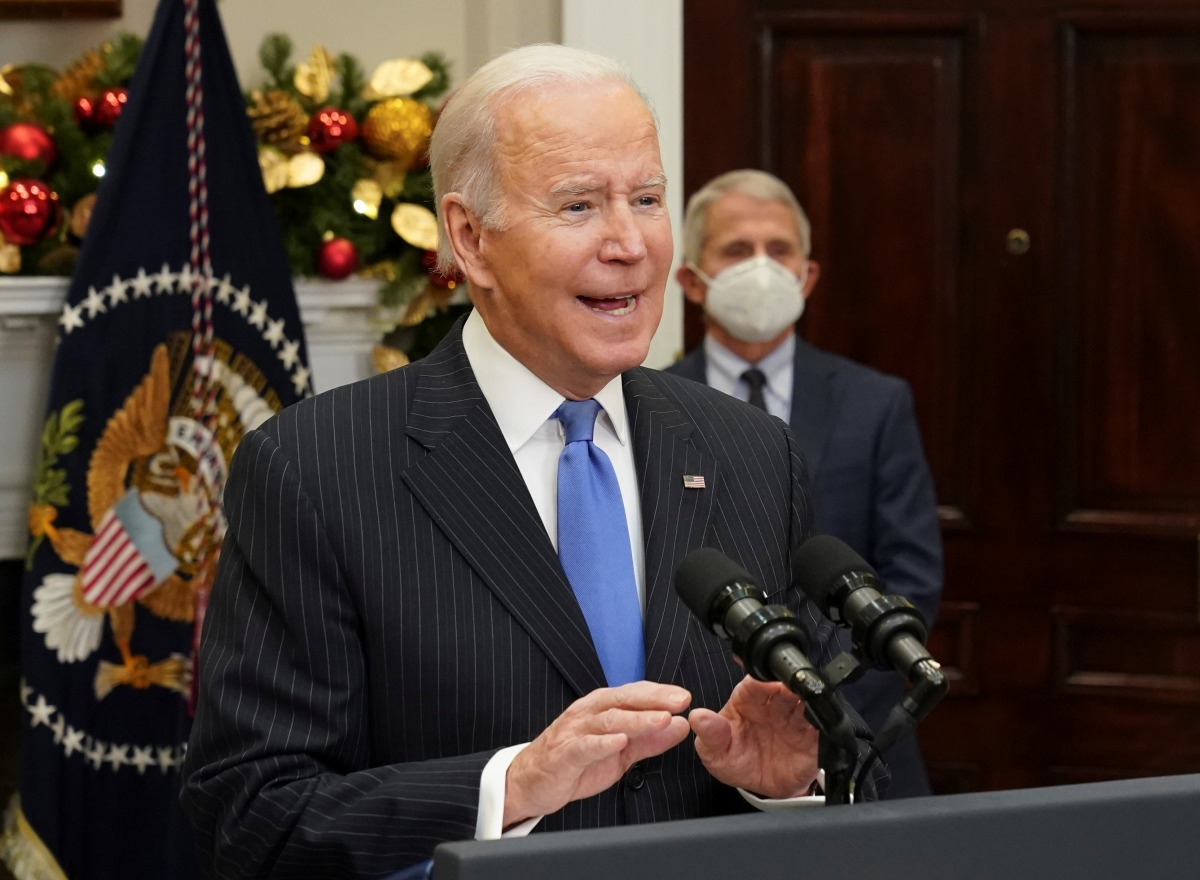 With Dr. Anthony Fauci standing behind, U.S. President Joe Biden delivers an update on the Omicron variant at the White House in Washington, U.S., November 29, 2021. REUTERS/Kevin Lamarque     
