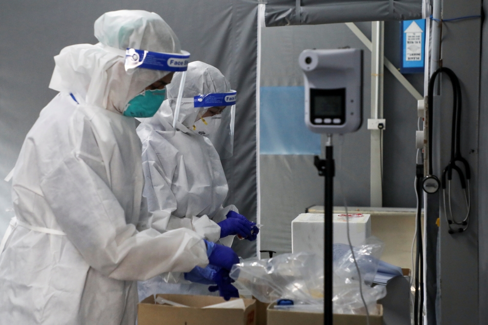 Medical workers are seen at the coronavirus disease (COVID-19) testing centre in Kuala Lumpur Hospital, in Kuala Lumpur, Malaysia February 16, 2021. REUTERS/Lim Huey Teng/File Photo