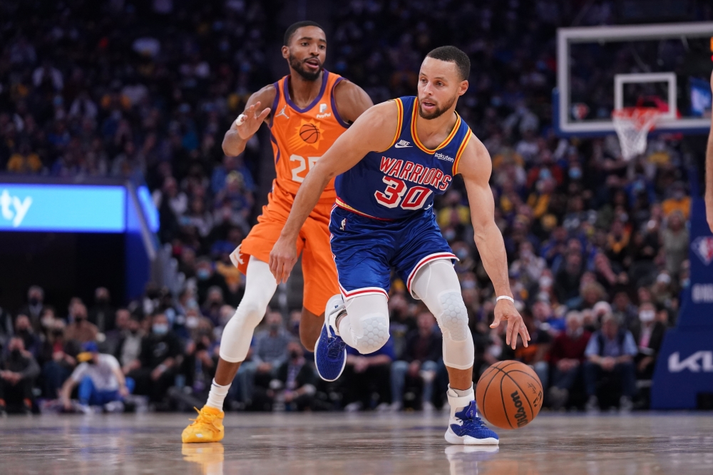 Golden State Warriors guard Stephen Curry (30) dribbles past Phoenix Suns forward Mikal Bridges (25) in the fourth quarter at the Chase Center. Cary Edmondson