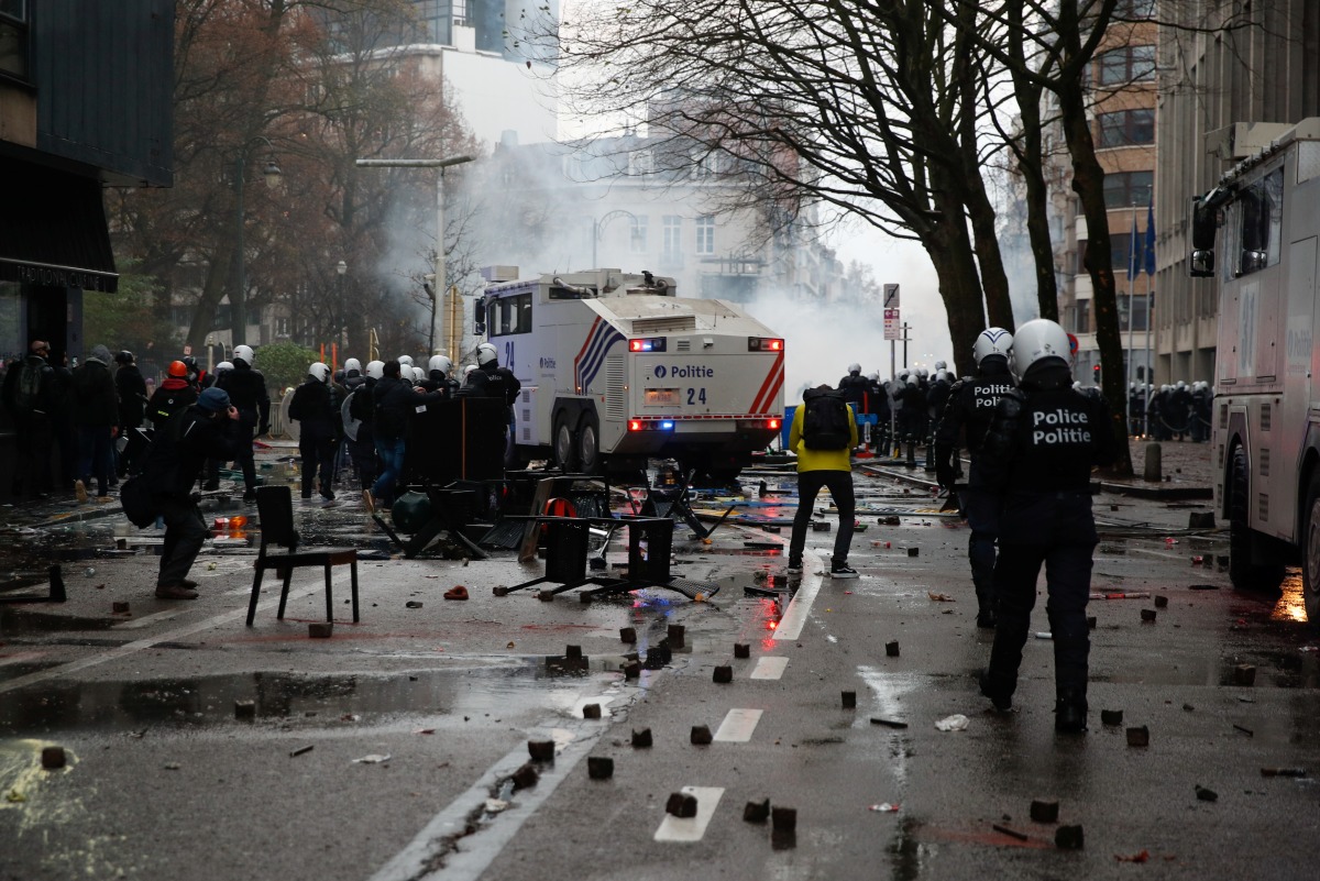Police officers walk on the street during a protest against the Belgian government's restrictions imposed to contain the spread of the coronavirus disease (COVID-19), in Brussels, Belgium December 5, 2021. REUTERS/Johanna Geron
