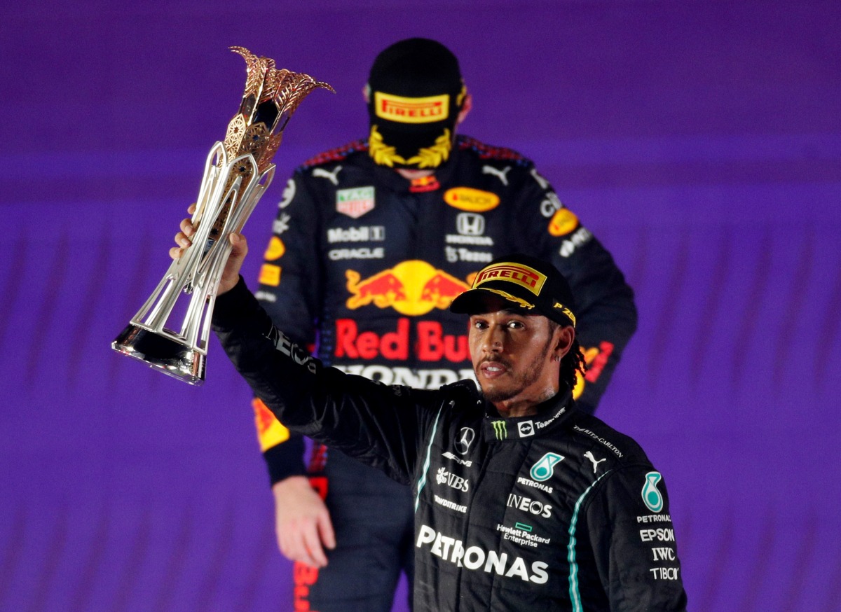 Mercedes' Lewis Hamilton celebrates with the trophy on the podium after winning the race as second placed Red Bull's Max Verstappen looks dejected REUTERS/Hamad I Mohammed TPX IMAGES OF THE DAY
