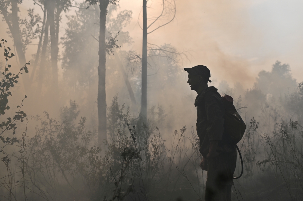A specialist of Russian Federal Agency for Forestry works to put out a forest fire outside the village of Basly in Omsk Region, Russia August 11, 2020. Reuters/Alexey Malgavko/File Photo
