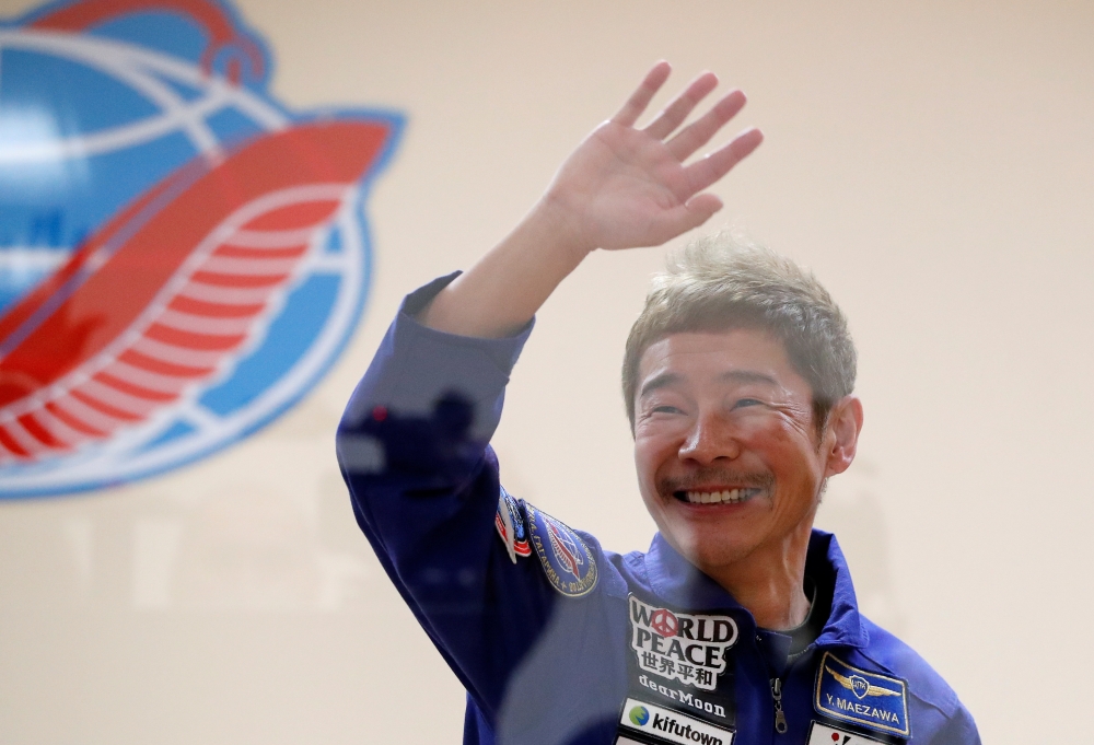 Japanese entrepreneur and space flight participant Yusaku Maezawa waves behind a glass wall during a news conference in Baikonur, Kazakhstan December 7, 2021. REUTERS/Shamil Zhumatov/Pool