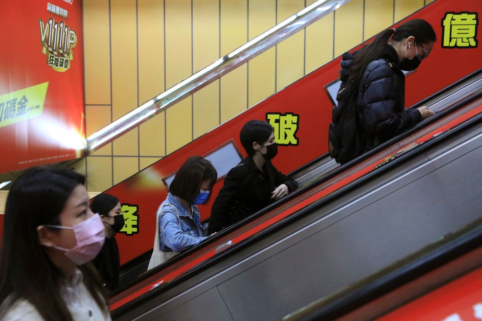 People wearing masks to prevent the spread of the coronavirus disease (COVID-19) ride on an escalator during morning rush hour at a subway station in Taipei, Taiwan, November 30, 2021. REUTERS/I-Hwa Cheng

