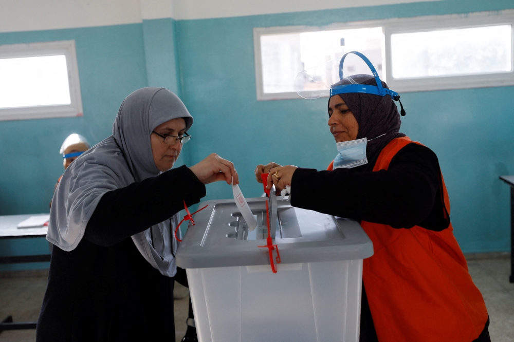 A Palestinian casts his ballot to vote in the municipal elections, near Jenin in the Israeli-occupied West Bank, December 11, 2021. REUTERS.