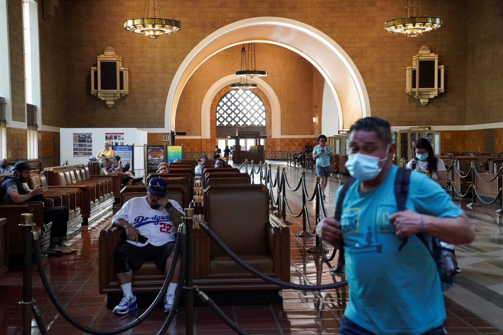 A traveller wearing a protective mask walks past a waiting area for Amtrak customers inside Union Station in downtown Los Angeles, California, U.S., August 21, 2021. REUTERS/Bing Guan/File Photo