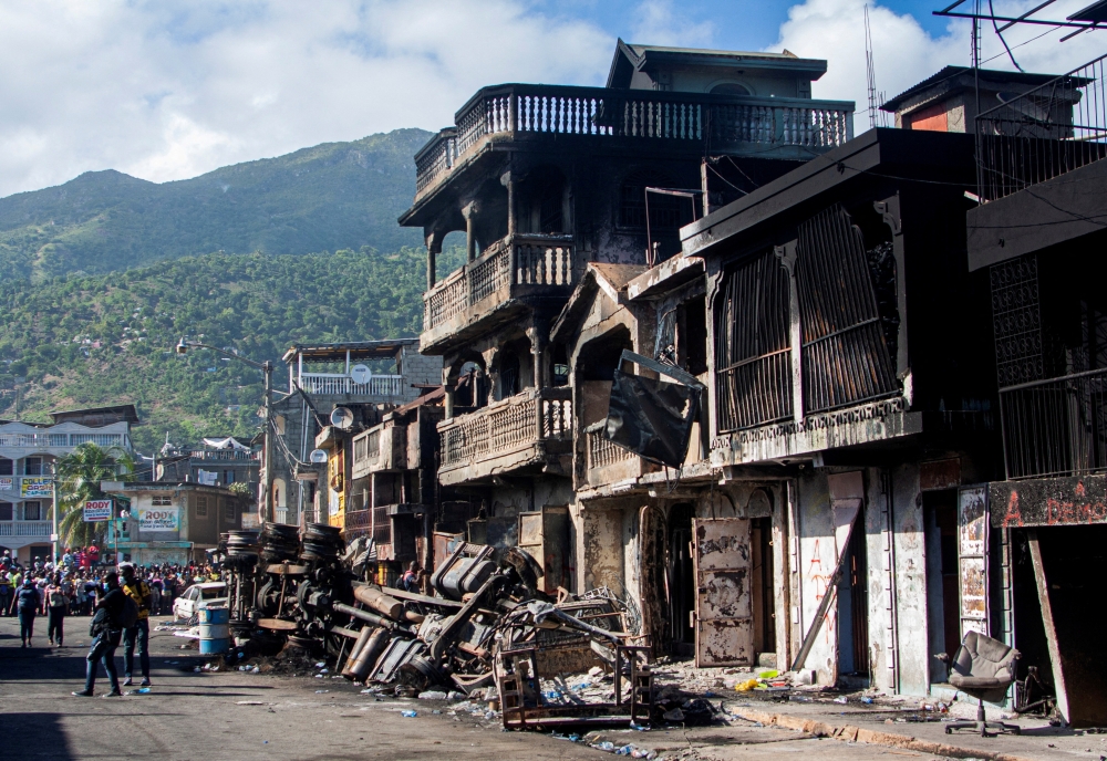 The remains of a fuel truck and burnt houses are seen after the truck exploded in a neighbourhood during the night, in Cap Haitien, Haiti, December 14, 2021. REUTERS/Samuel Volcy