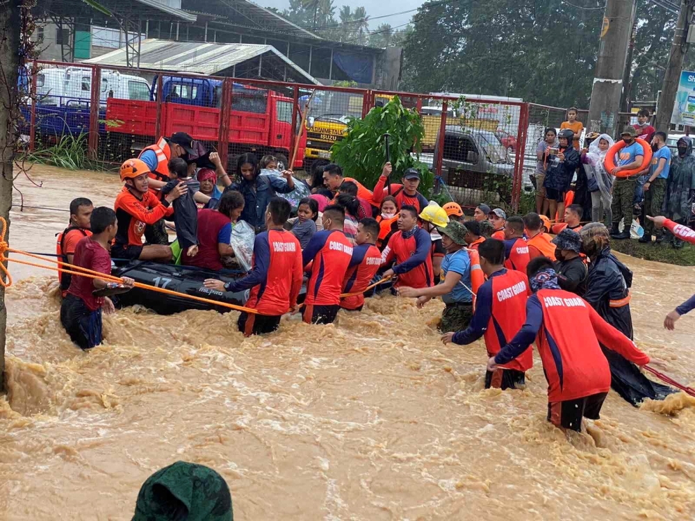 Philippine Coast Guard personnel rescue residents after being inundated by floods caused by Typhoon Rai in Cagayan De Oro City, Philippines, December 16, 2021. Philippine Coast Guard/Handout via REUTERS