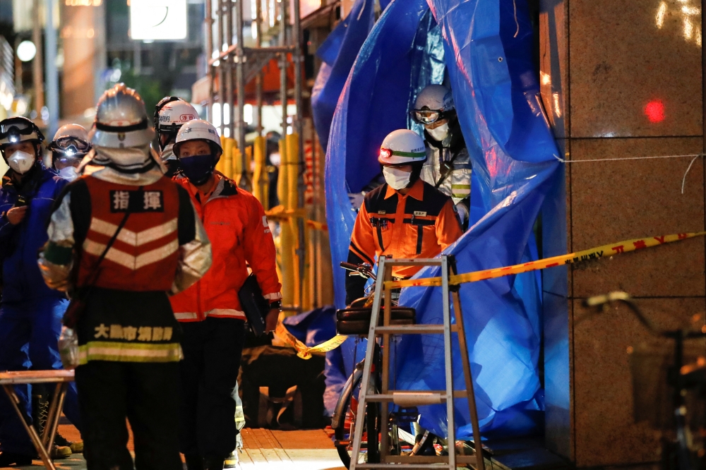 Firefighters work outside a building where a fire broke out in Osaka, Japan December 17, 2021. REUTERS/Kim Kyung-Hoon