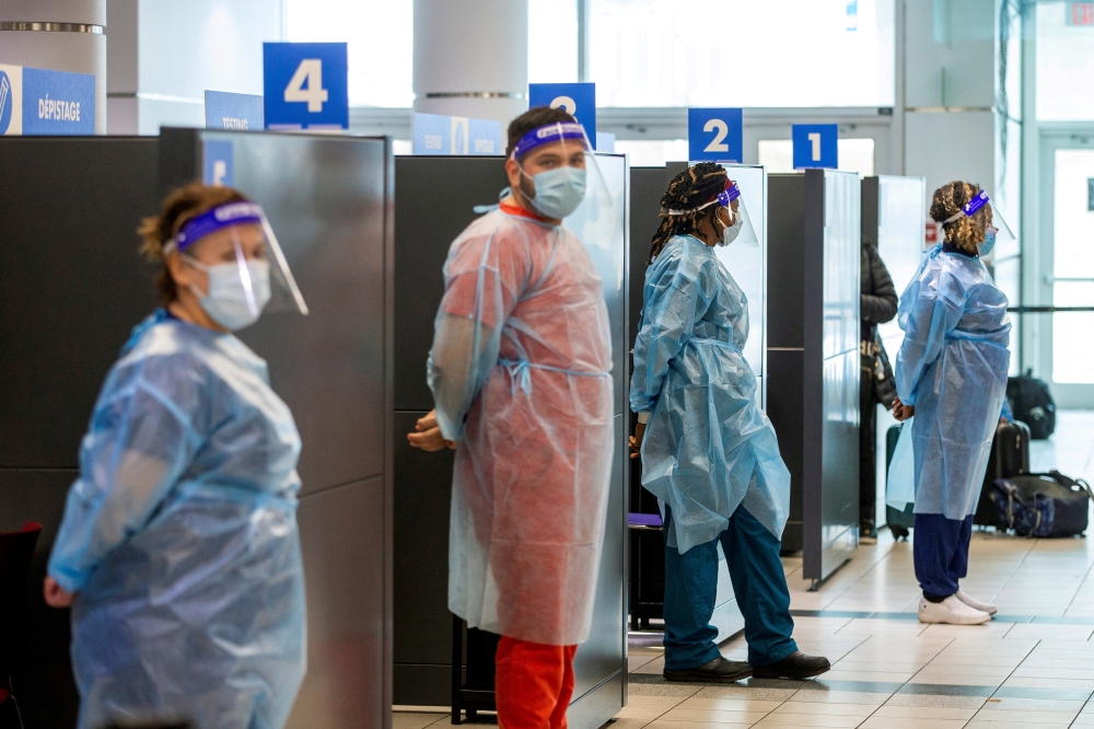 Healthcare workers prepare to test passengers as they arrive at Toronto's Pearson airport after mandatory coronavirus disease (COVID-19) testing took effect for international arrivals in Mississauga, Ontario, Canada February 1, 2021. REUTERS/Carlos Osorio/File Photo